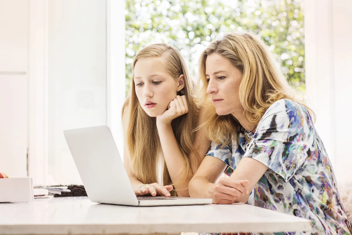 A parent and student looking at a laptop together